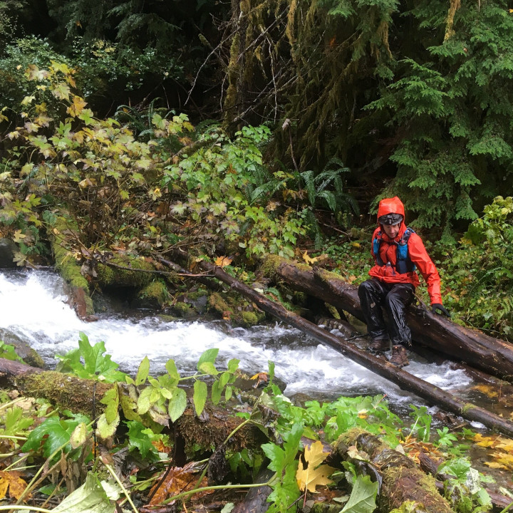Carl crossing a creek on a rainy SAR training day